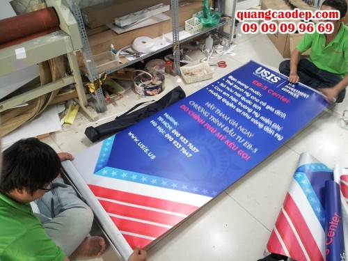 Nhân viên gia công của In Kỹ Thuật Số đang lắp banner cuốn cho poster đặt in từ khách hàng